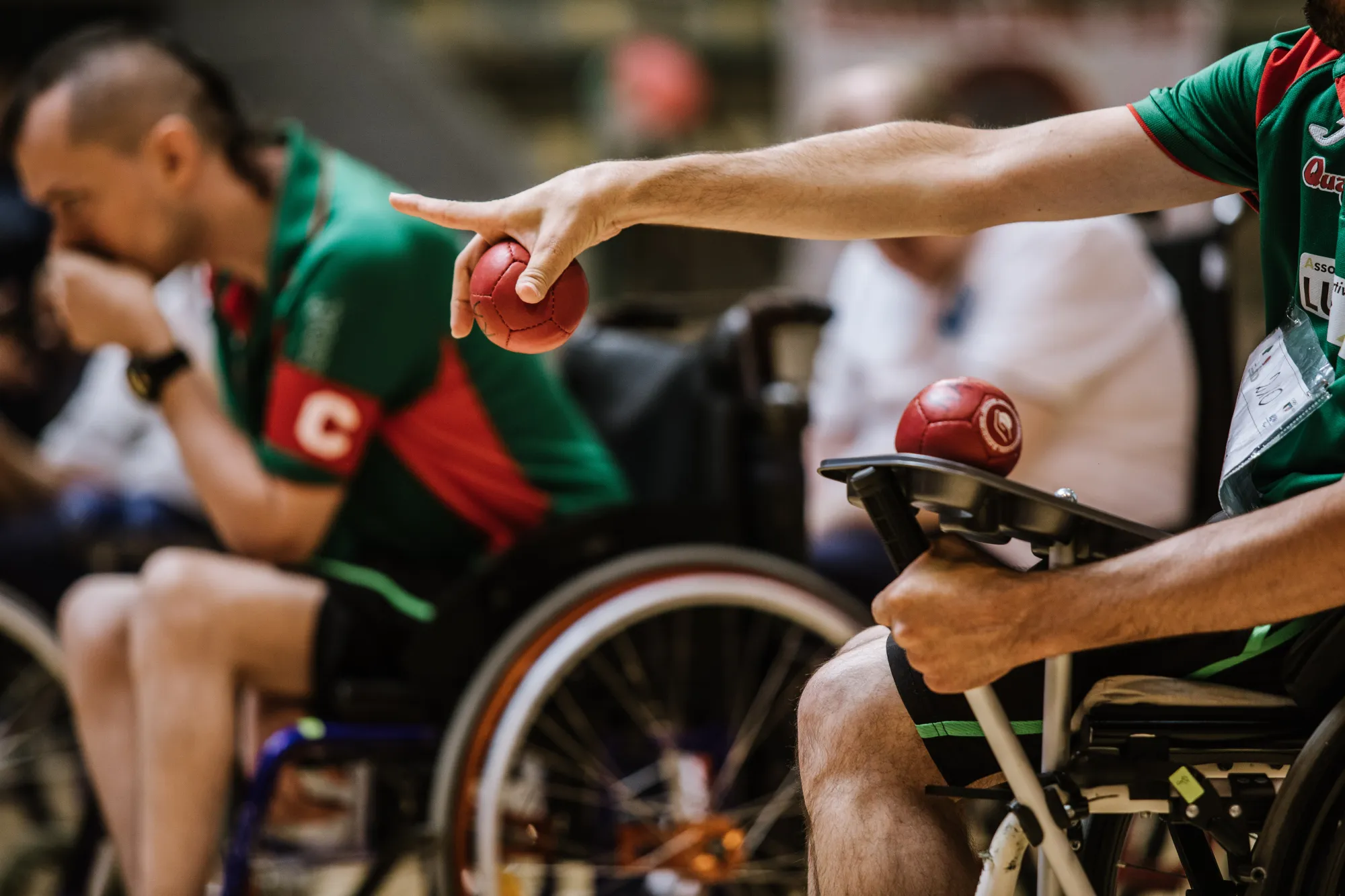 Un atleta prepara il lancio di una boccia rossa durante una gara.